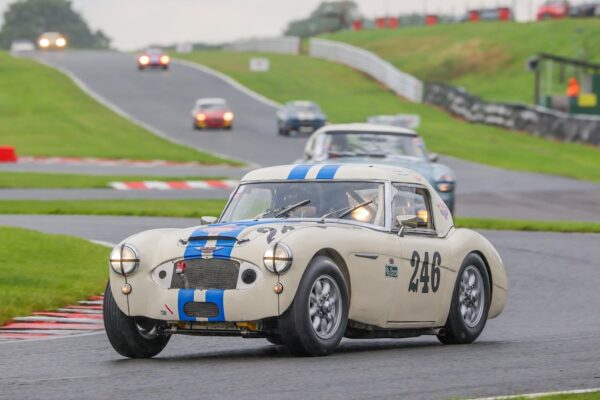 Jack Rawles driving Austin Healey 3000 FSL 246 at Oulton Park race circuit. Leading the pack of classic race cars.